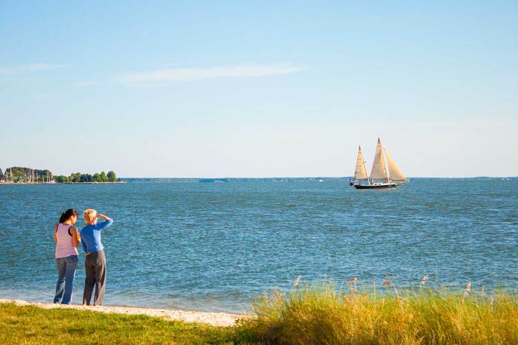 People looking at bay with Sailboat