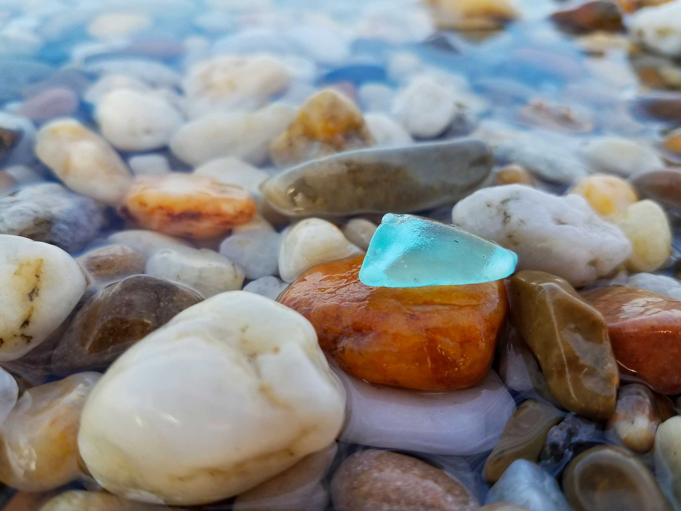 Blue sea glass with pebbles on a Maryland beach