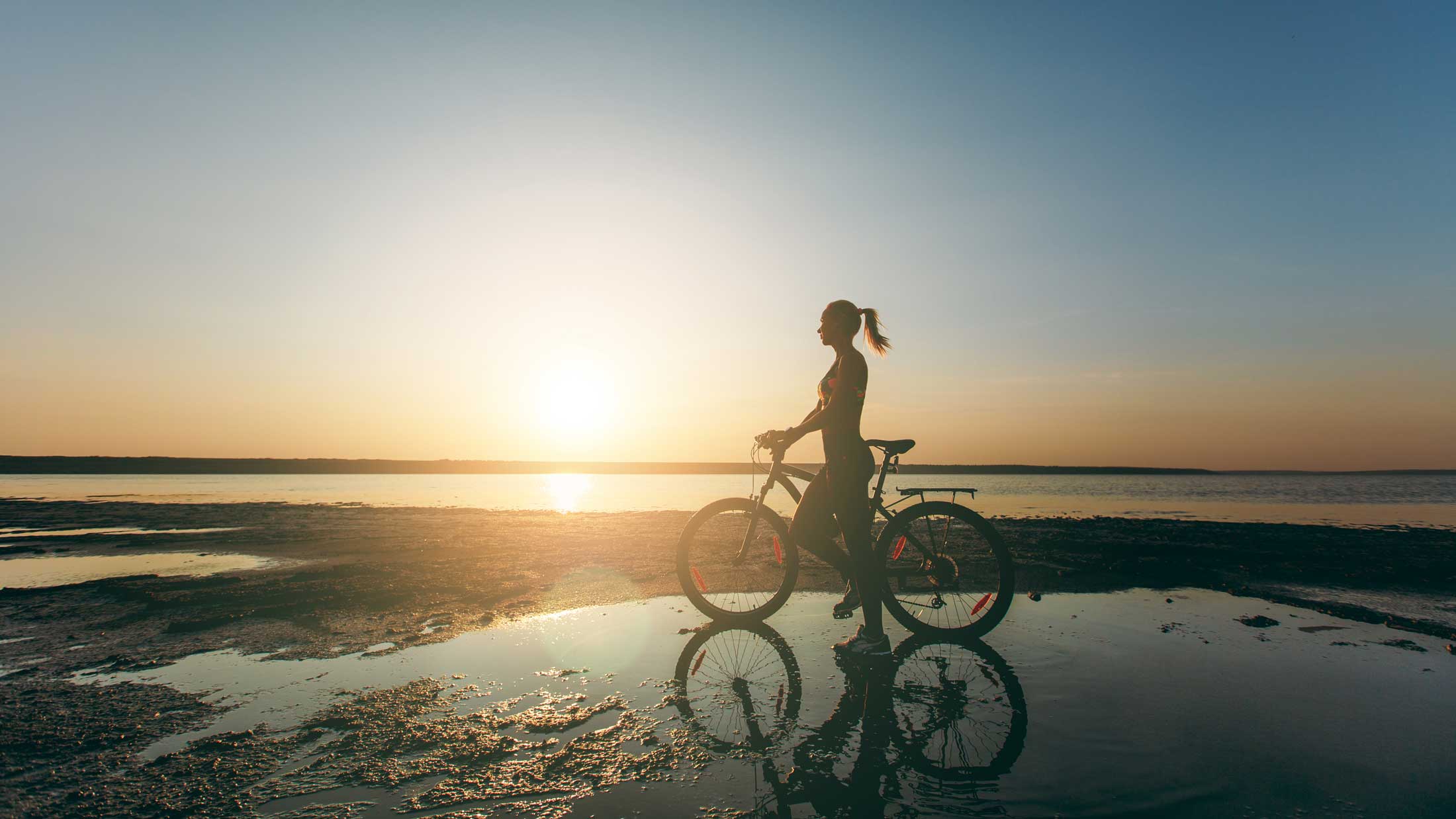 Biking a natural shoreline at sunset